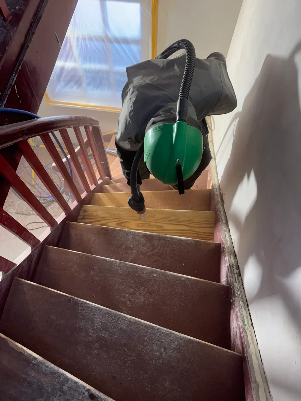 Sandstrahlen einer Holztreppe – eine Stufe ist bereits vom Anstrich befreit