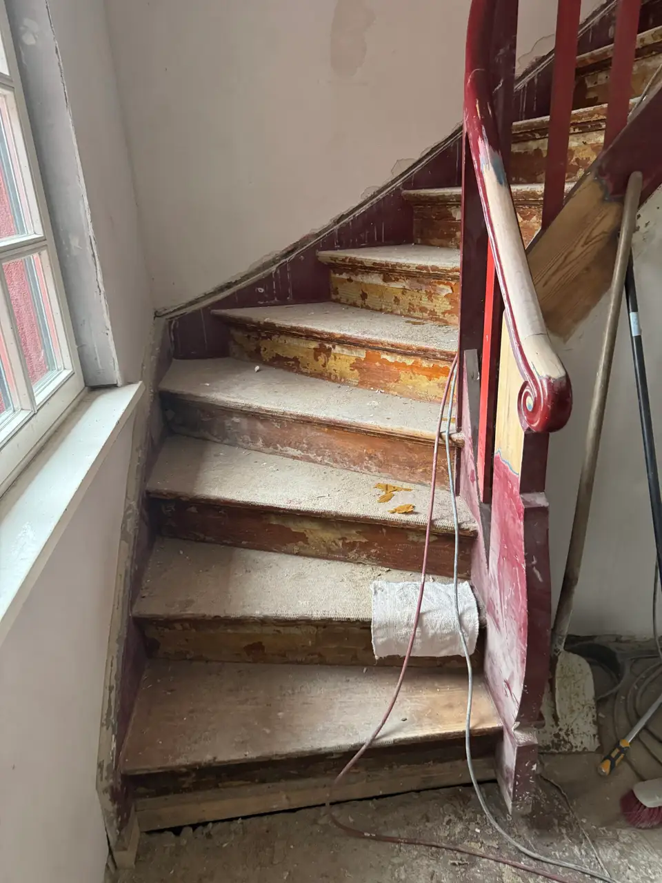 Holztreppe vor dem Sandstrahlen – alte Farbschichten blättern von den Stufen ab